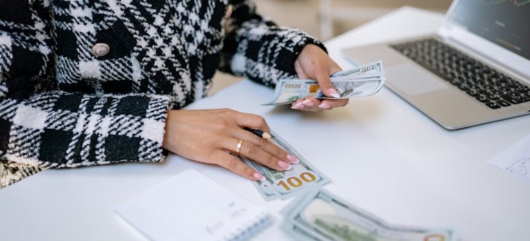 Hands counting cash for a down payment on a Denver home