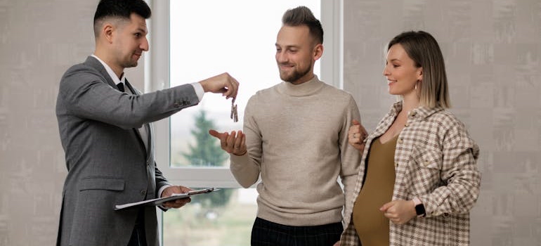 A couple getting the keys to a house in one of the top spots in Colorado for couples living together for the first time