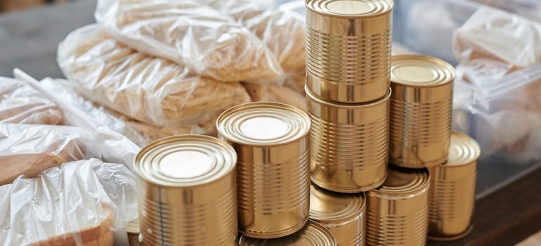 Canned food and boxes of pasta sorted on a counter before packing