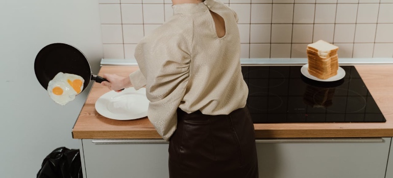 A woman throwing eggs into the trash