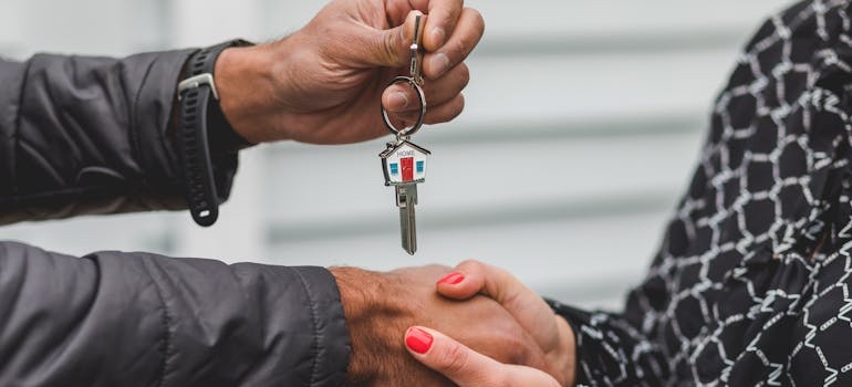 A real estate agent handing house keys to a student renting off campus housing in Oxford MS