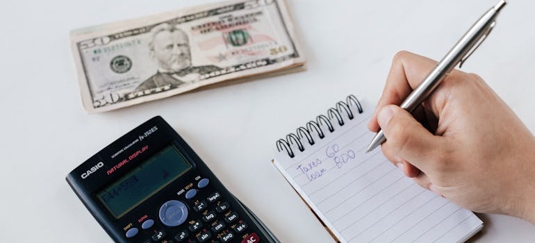 A person working out a moving budget to avoid overspending