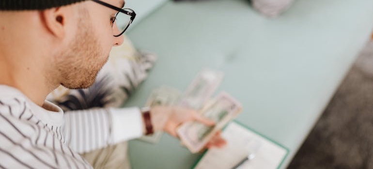 Hands counting dollar bills over a table