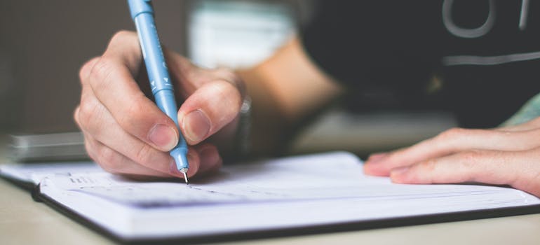 A person writing a to-do list in a notebook