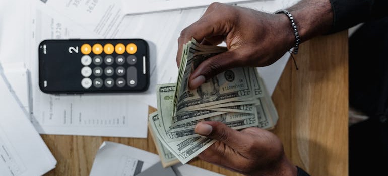 Hands counting cash bills on a table