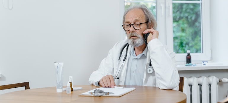 Senior doctor in a white coat at a medical office