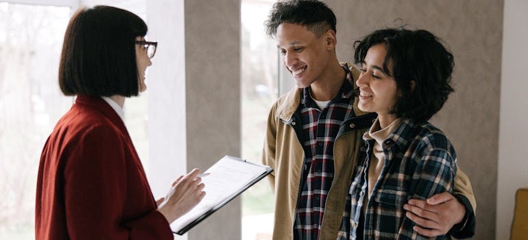 Real estate agent showing a couple a home for sale