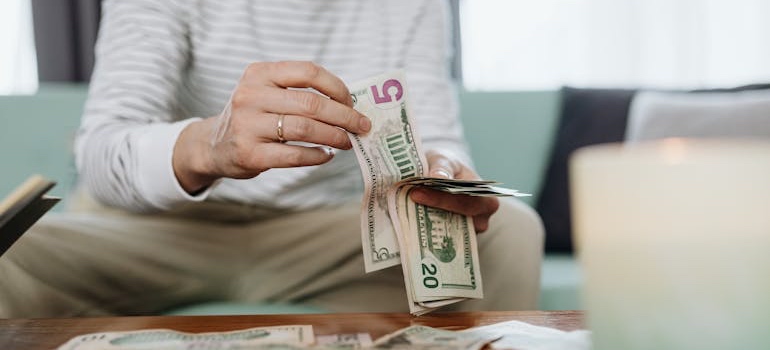 Person counting cash while planning a household budget