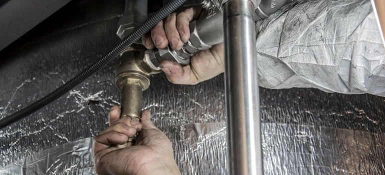 A plumber helping a homeowner with home maintenance