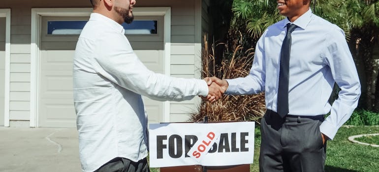 Real estate agent shaking hands with a buyer after a home sale