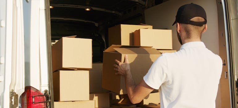 Mover loading packed boxes into a van