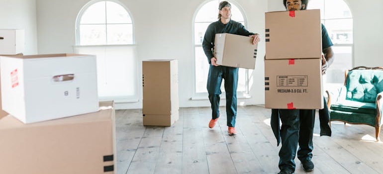 Movers carrying moving boxes know what to do with packing materials after a move 