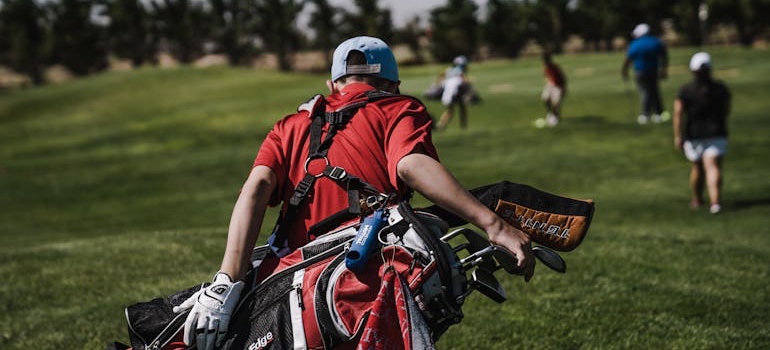 Golfers walking with their bags on a green course in one of the top Colorado communities for active seniors