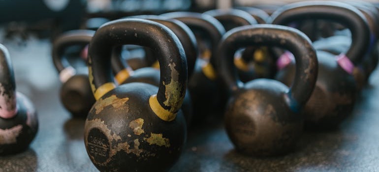 Kettlebells lined up before someone starts packing a home gym for a move