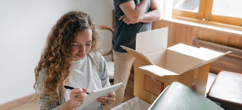 Two people packing moving boxes in an apartment