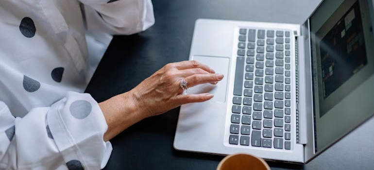 A person using a laptop to research storage facilities for rare collectibles
