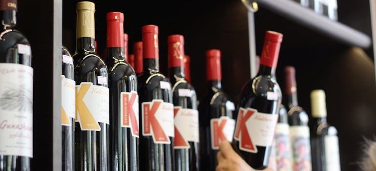 Wine bottles on a shelf, one item on the list of what you should never store in a Mississippi storage unit during summer