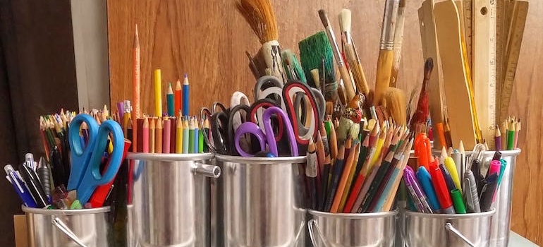 Colored pencils, notebooks and other school supplies on a table