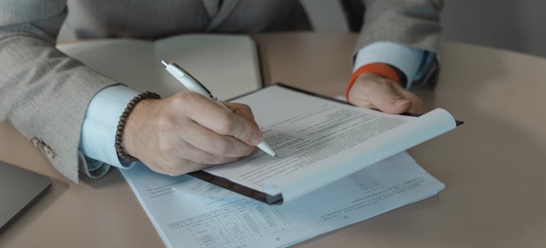 A person filling out a Colorado vehicle title and registration application