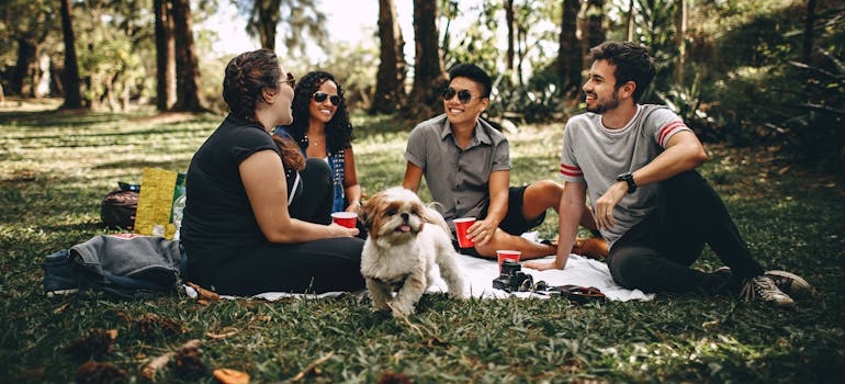 Friends talking in a park while comparing Denver neighborhoods for renters who plan to buy later