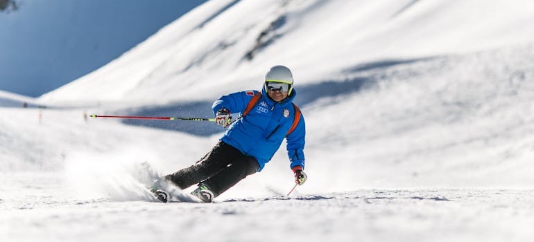 A skier going down a snowy mountain slope