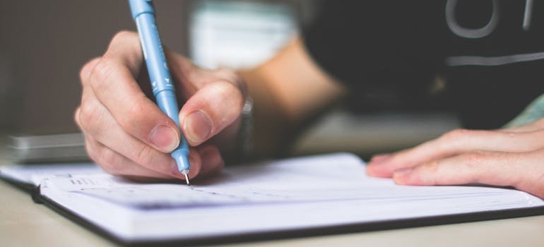A person checking off items on a checklist from a guide for moving from Mississippi to NC