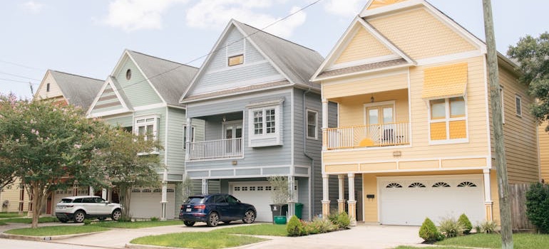 A quiet suburban street lined with two-story houses and young trees