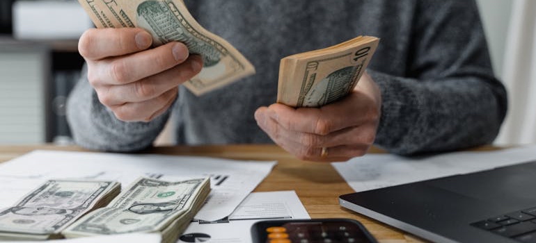 Person with a calculator and notebook budgeting for a move