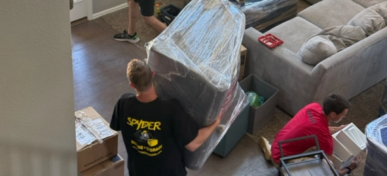 Spyder crew wrapping furniture in a living room