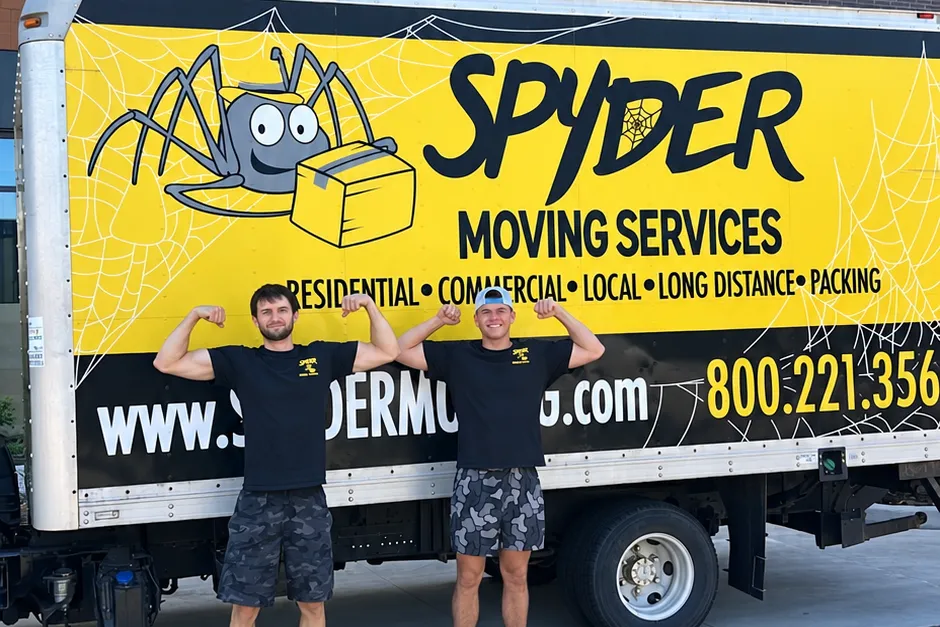Two Denver movers from Spyder standing in front of a company moving truck