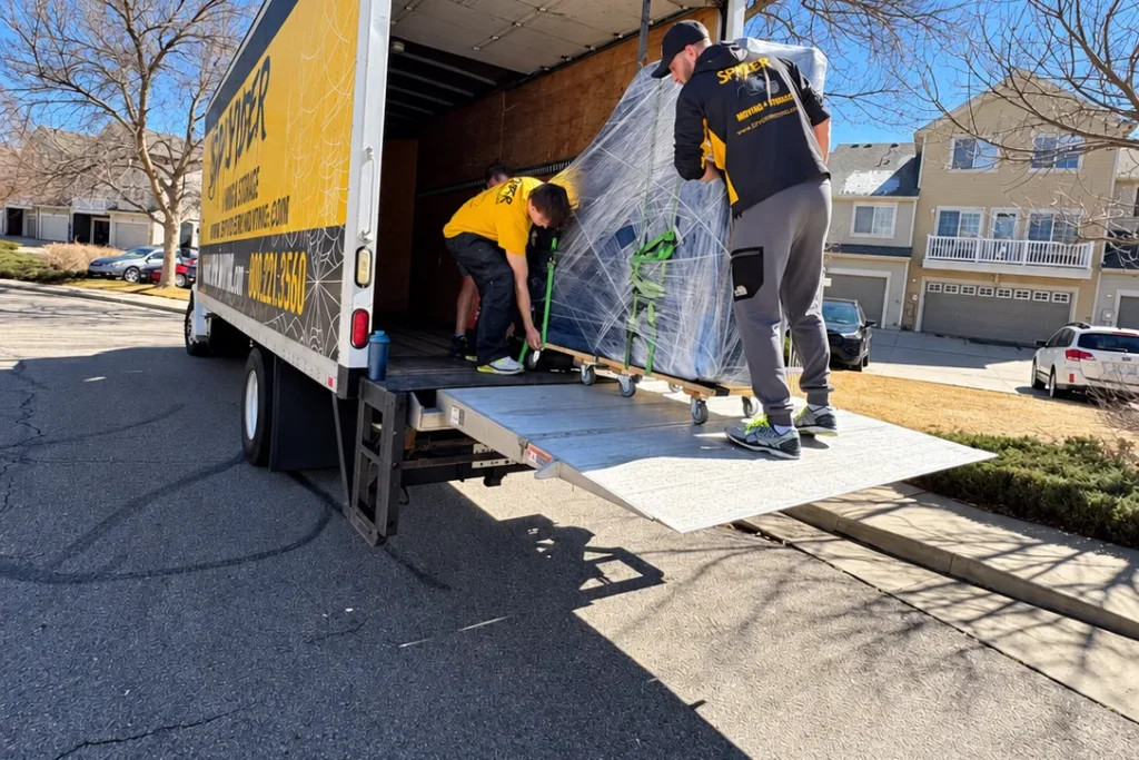 Spyder movers wrapping furniture on the truck liftgate