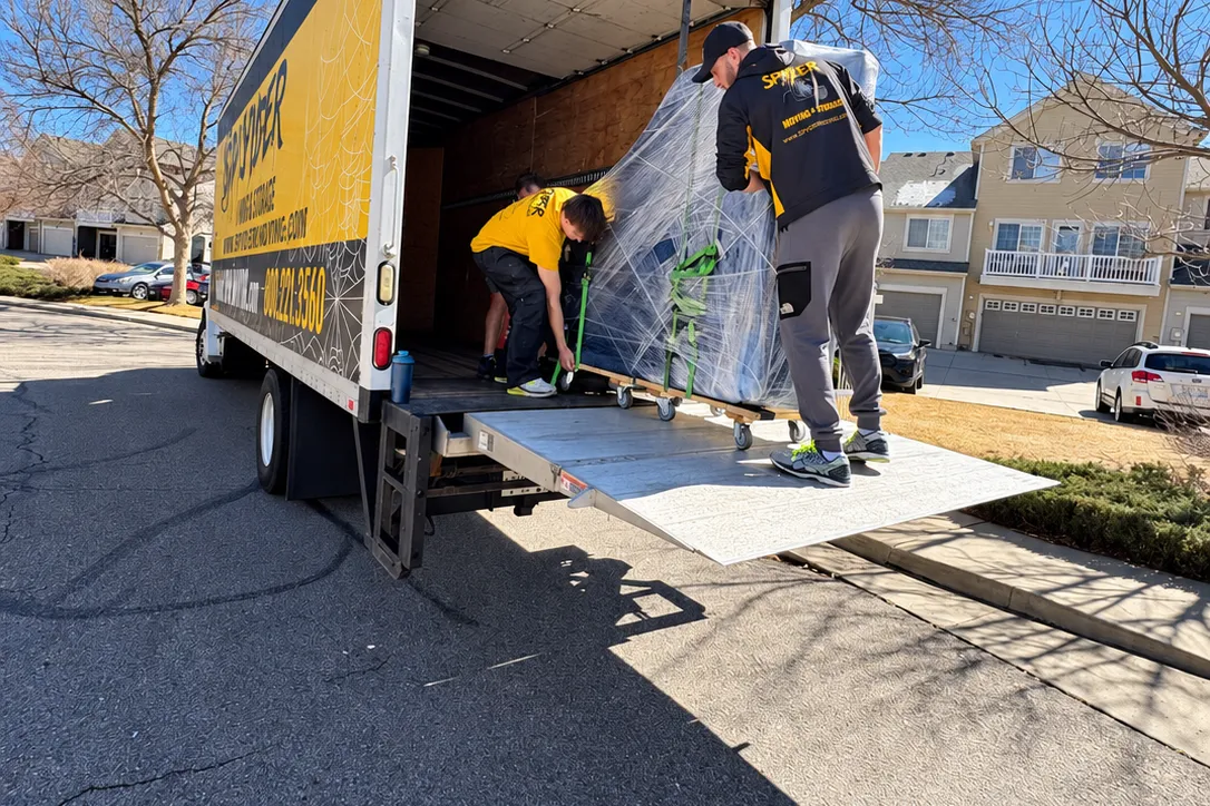 Spyder movers loading shrink-wrapped furniture into a truck before a Hernando move