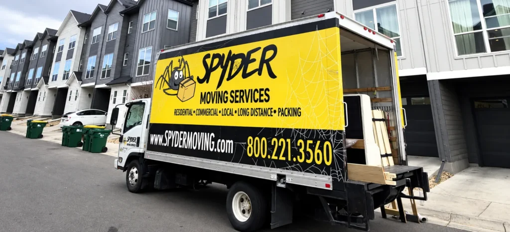 Spyder box truck parked outside a row of townhomes